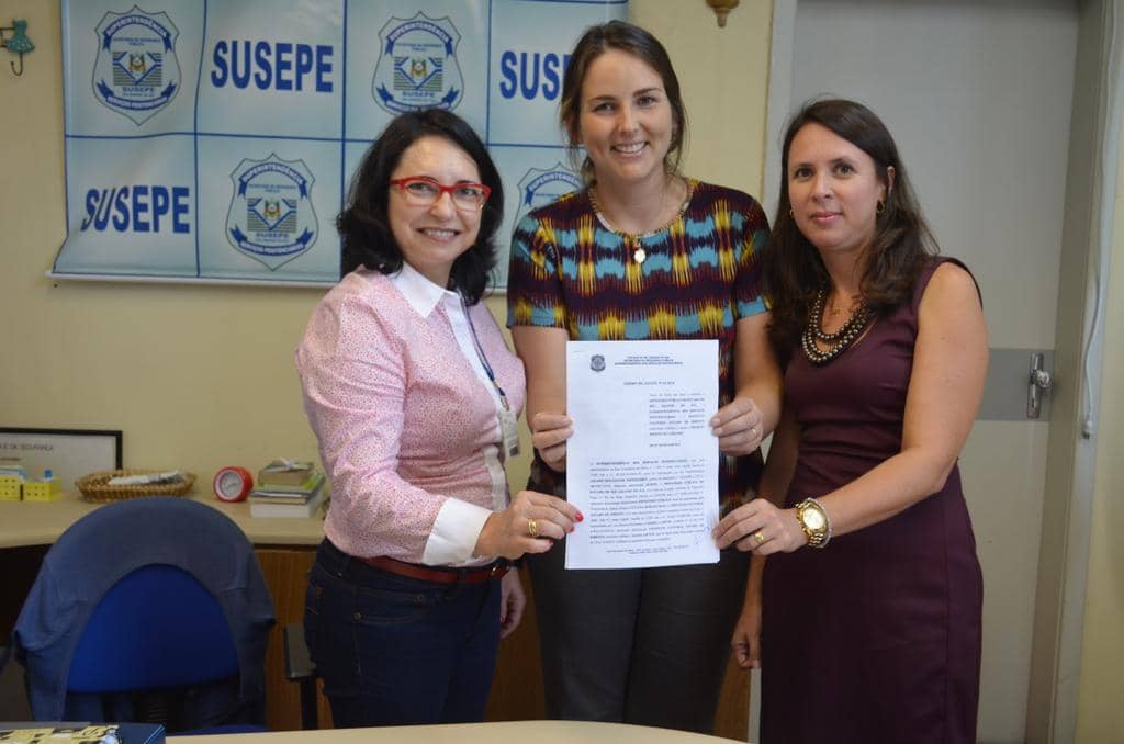 Promotora Luciana Dias (D) com o documento assinado